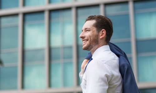 [Imagem de uma pessoa sorrindo, olhando para um gráfico de crescimento, com um horizonte de prédios ao fundo]